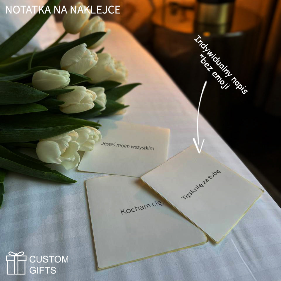 Three personalized stickers with loving messages on a bed, surrounded by fresh white tulips.